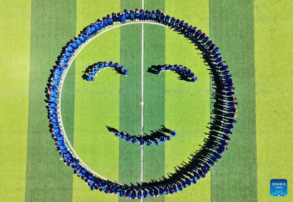 An aerial drone photo taken on May 7, 2026 shows students gathering to form a smiling face symbol on the playground at a middle school in Handan City, north China's Hebei Province. May 8 marks the World Smile Day. (Photo by Hao Qunying/Xinhua)

