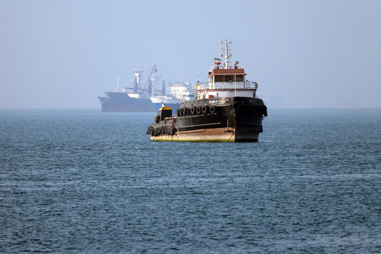 In this picture obtained from Iran's ISNA news agency on May 4, 2026, the Iran-flagged tugboat Basim sails near a ship anchored in the Strait of Hormuz off Bandar Abbas in southern Iran. Photo: VCG