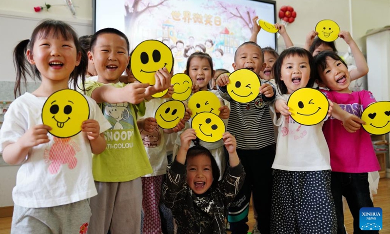 Children holding smiling face props play a game at a kindergarten in Qinyang City, central China's Henan Province, May 7, 2026. May 8 marks the World Smile Day. (Photo by Zhang Xinyu/Xinhua)

