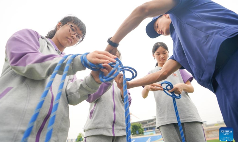Students learn to use rescue knots under the guidance of a firefighter at Tianfu New Area, southwest China's Sichuan Province, May 11, 2026. A variety of activities were held across the country marking the upcoming National Disaster Prevention and Reduction Day. (Photo by Weng Guangjian/Xinhua)