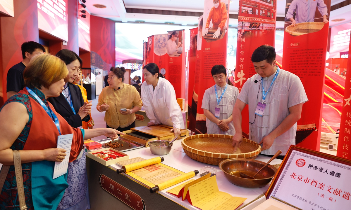 Visitors explore exhibits at a special exhibition marking the Brilliant China Third Cross-Straits Chinese Culture Summit at the Cultural Palace of Ethnic Communities in Beijing on May 10, 2026. The exhibition features three sections highlighting intangible cultural heritage, cultural and creative products, and traditional calligraphy and painting.