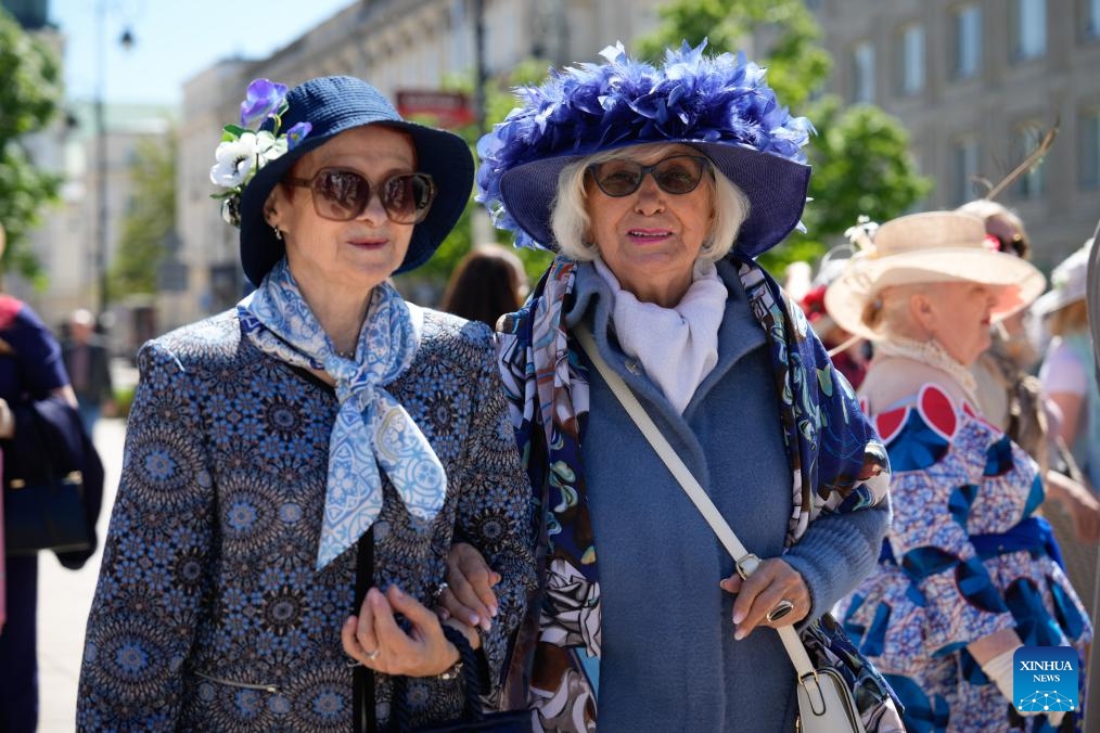 Women wearing decorative hats take part in the Hat Walk Warsaw event in Warsaw, Poland, May 10, 2026. Participants of the Hat Walk Warsaw event walked along main streets in the city's Old Town to showcase creativity and personal style. (Photo: Xinhua)