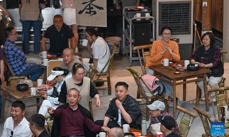 People enjoy their leisure time at a tea house in Chongqing, southwest China, May 10, 2026. Originally built in the 1950s as a workers' cinema of a local machinery factory in Chongqing, the building has been renovated into a public tea house called Jiangling tea house now, integrating dining, leisure, and cultural creativity, favored by both local citizens and tourists. (Photo: Xinhua)