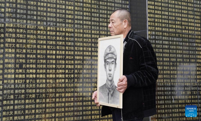 A relative holds the portrait of a Red Army martyr at the Ruijin revolutionary martyrs' cemetery in Ruijin, east China's Jiangxi Province, April 1, 2026. (Xinhua/Zhou Mi)