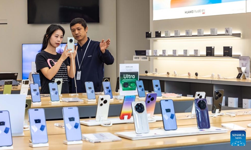 Customers choose digital products at a digital store in Anshun City, southwest China's Guizhou Province, on May 11, 2026. (Photo by Chen Xi/Xinhua)