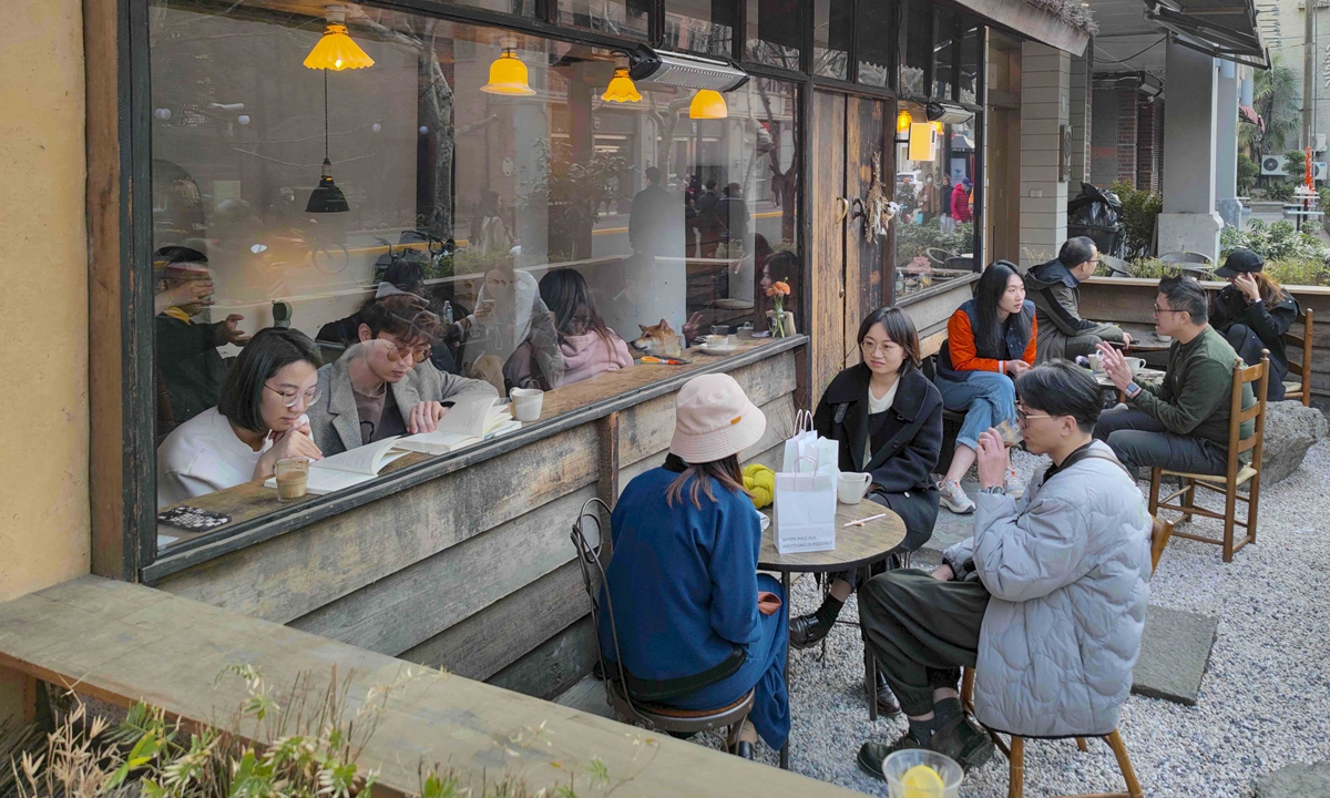 People drink coffee outside a coffee shop in Shanghai. Photo: VCG