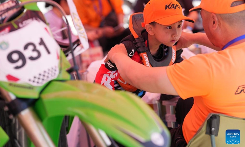 A young racer receives his coach's instruction before a motocross league event held in the Xixian New Area of northwest China's Shaanxi Province, May 4, 2026. (Xinhua/Li Yibo)

