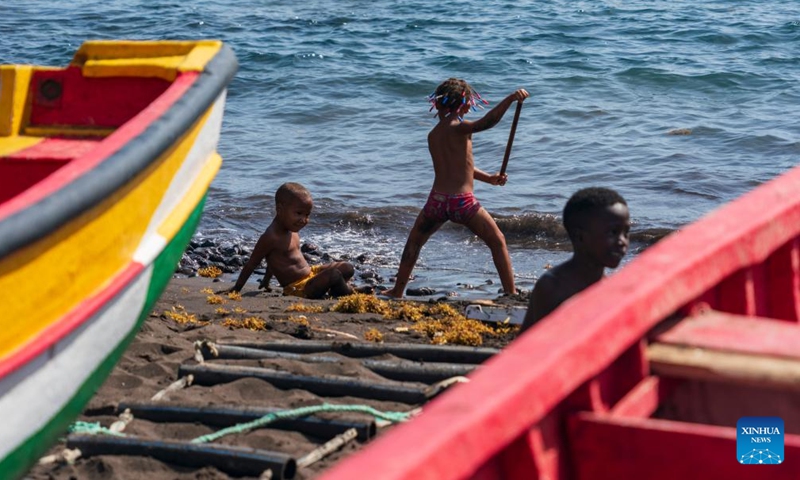 Children play beside painted fishing boats on the seaside of Cidade Velha, Santiago Island, Cape Verde, May 11, 2026. Santiago Island, located in the southern part of the Cape Verde archipelago, is the country's largest and most populous island. (Xinhua/Xie Jianfei)
