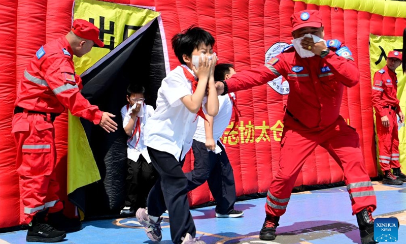 Students take part in an emergency evacuation drill under the guidance of firefighters in Taicang City, east China's Jiangsu Province, May 12, 2026. A variety of activities were held across the country marking the National Disaster Prevention and Reduction Day on Tuesday. (Photo by Ji Haixin/Xinhua)