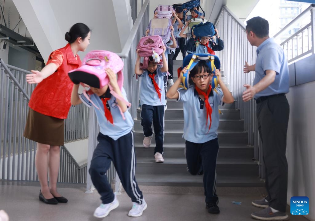 Students take part in an emergency evacuation drill at a primary school in Wuhan City, central China's Hubei Province, May 12, 2026. A variety of activities were held across the country marking the National Disaster Prevention and Reduction Day on Tuesday. (Photo by Zhao Jun/Xinhua)
