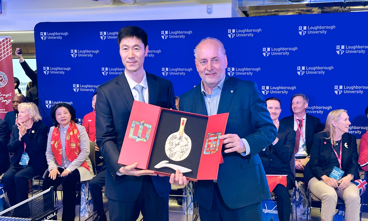 Chinese and UK representatives exchange gifts at an event marking the 55th anniversary of the China-UK 