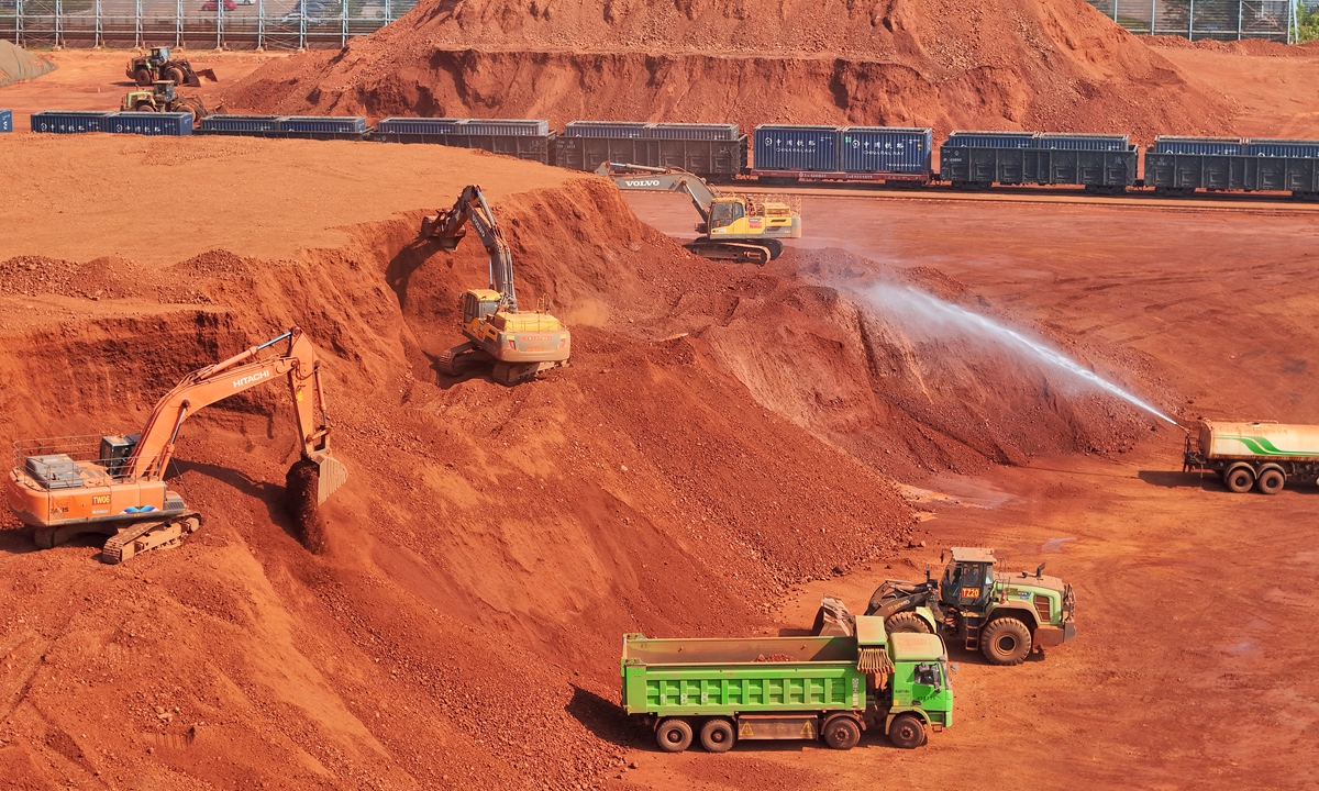 Construction machinery and trucks carry out loading work at an imported bauxite yard in Yantai, Shandong Province, May 13, 2026. Photo: VCG