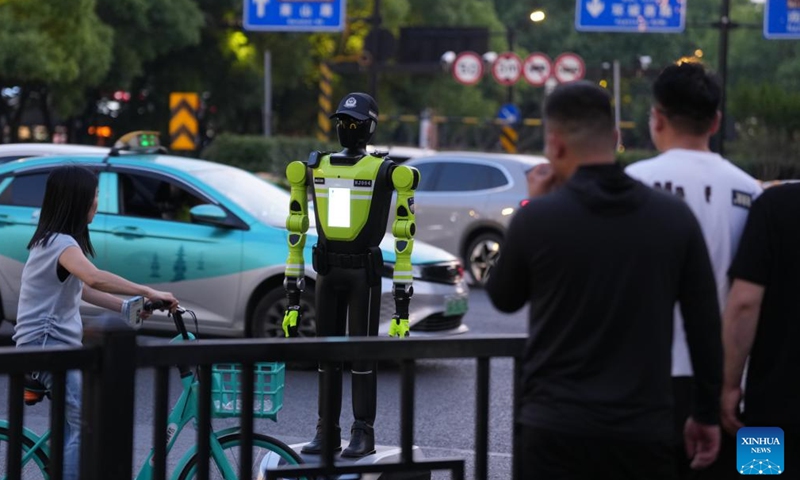 An intelligent traffic management robot is on duty at a crossroad in the Hubin business area of Hangzhou, east China's Zhejiang Province, May 11, 2026. Fifteen intelligent traffic management robots have been deployed at key intersections of the West Lake scenic area, Hubin business area, and main urban roads in Hangzhou, undertaking the tasks such as showing the way for tourists, dissuading riders of non-motorized vehicles and pedestrians from violating traffic rules, and directing the traffic. (Xinhua/Huang Zongzhi)