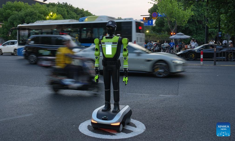 An intelligent traffic management robot is on duty at a crossroad in the Hubin business area of Hangzhou, east China's Zhejiang Province, May 11, 2026. Fifteen intelligent traffic management robots have been deployed at key intersections of the West Lake scenic area, Hubin business area, and main urban roads in Hangzhou, undertaking the tasks such as showing the way for tourists, dissuading riders of non-motorized vehicles and pedestrians from violating traffic rules, and directing the traffic. (Xinhua/Huang Zongzhi)
