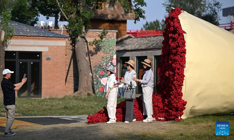 Tourists pose for photos at a tourism and leisure block in Zhongbei Town of Xiqing District in north China's Tianjin, May 12, 2026. Recently, a tourism and leisure block opened to the public in Tianjin. Covering about 45,000 square meters, the district was transformed from abandoned buildings of a yarn-dyed fabric factory. (Xinhua/Li Ran)
