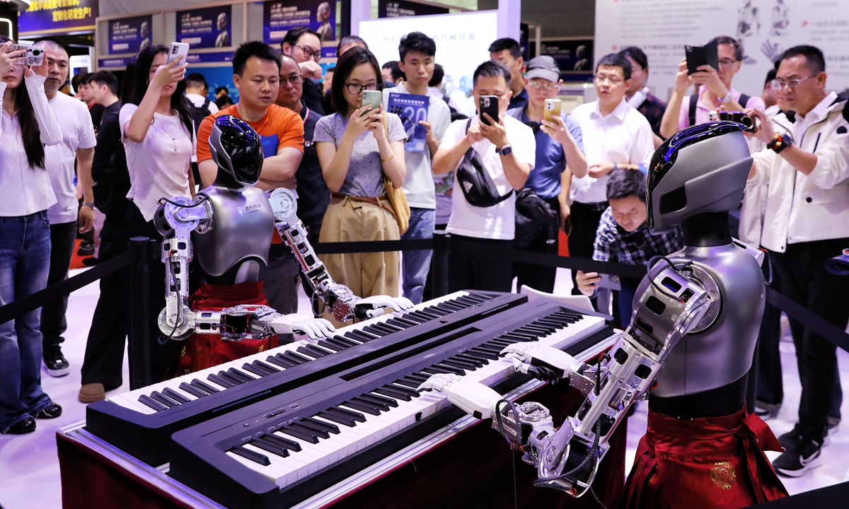 Tourists take photos as humanoid robots play the piano at the 2026 Second Hangzhou International Humanoid Robot and Robotics Technology Exhibition at the Hangzhou Convention and Exhibition Center in Zhejiang Province on May 14, 2026. 
Photo: VCG