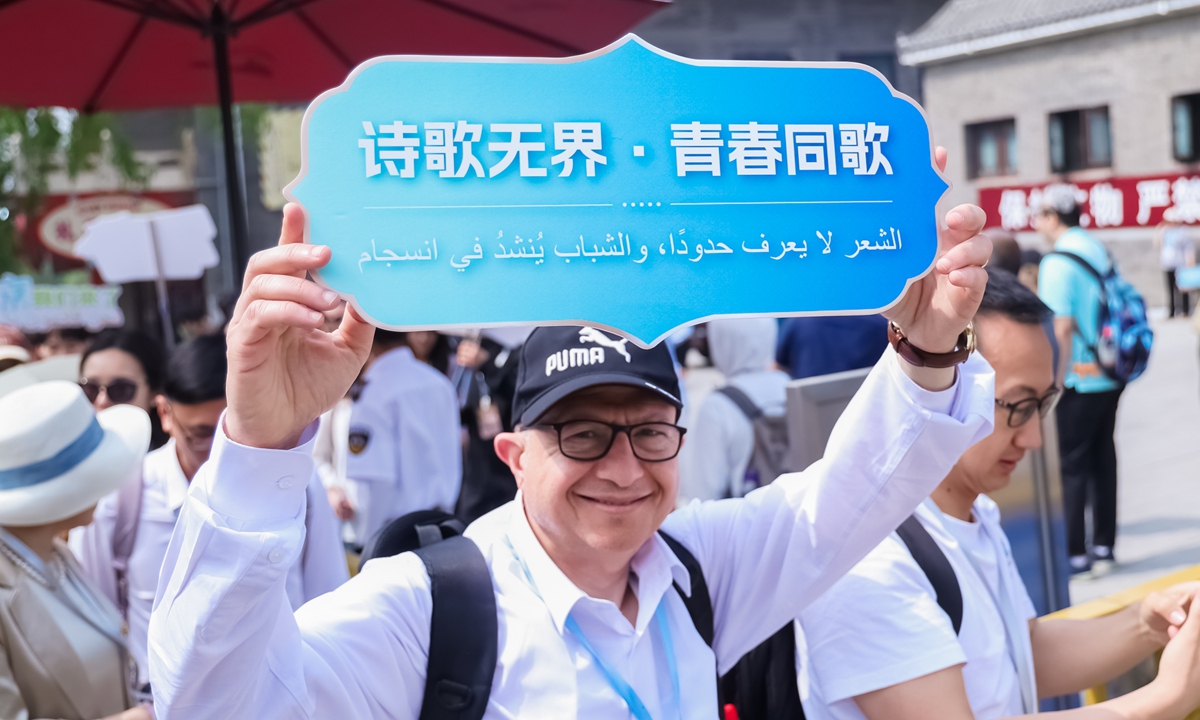 Egyptian poet Mouner Oteiba holds a banner that reads 