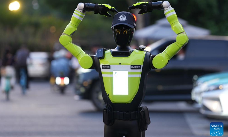 An intelligent traffic management robot makes a heart gesture for pedestrians at an intersection in the Hubin business area of Hangzhou, east China's Zhejiang Province, May 11, 2026. Fifteen intelligent traffic management robots have been deployed at key intersections of the West Lake scenic area, Hubin business area, and main urban roads in Hangzhou, undertaking the tasks such as showing the way for tourists, dissuading riders of non-motorized vehicles and pedestrians from violating traffic rules, and directing the traffic. (Xinhua/Huang Zongzhi)