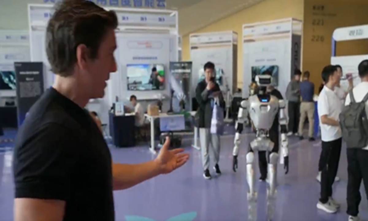 ABC World News Tonight's anchor David Muir interacts with a humanoid robot displayed at a major AI conference in Beijing. Photo: Screenshot of a ABC News report 