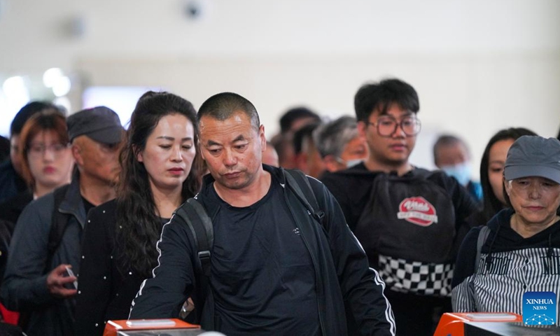 People prepare to board train No. K5153 traveling from Harbin to Fuyuan at Harbin East Railway Station in Harbin, northeast China's Heilongjiang Province, May 13, 2026. The Sanjiang Plain in Heilongjiang Province is a leading grain-producing area in China. Workers are needed there during the transplanting season for rice seedlings.


