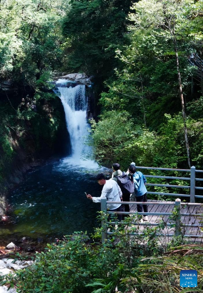 Tourists visit a waterfall at a scenic area in Jinping Miao, Yao and Dai Autonomous County, southwest China's Yunnan Province, May 14, 2026. In early summer, the waterfall clusters in Jinping attracted many tourists. (Xinhua/Chen Xinbo)