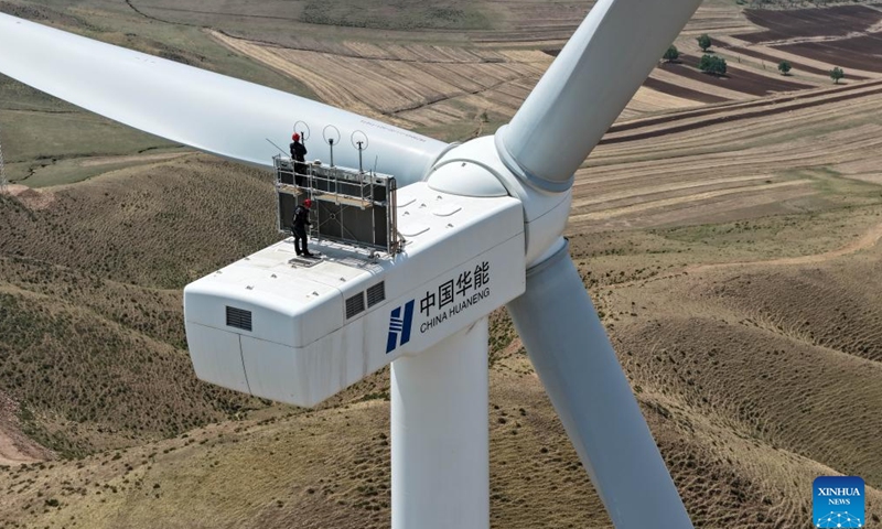 An aerial drone photo shows workers carrying out routine inspections of wind turbines at a new energy base in Zhenglan Banner of Xilingol League, north China's Inner Mongolia Autonomous Region, May 14, 2026.

