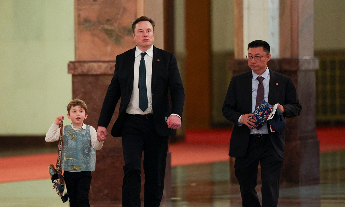Tesla CEO Elon Musk, his son, and Zhu Xiaotong, Senior Vice President of Tesla Automotive, walk on in the Great Hall of the People as Chinese Premier Li Qiang meets with American CEOs, in Beijing, China, May 14, 2026. Photo: VCG