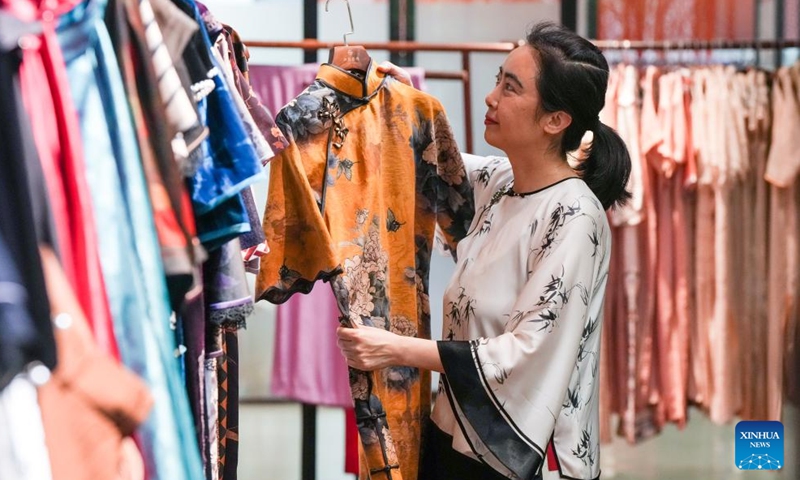 A shop owner arranges Qipao, a traditional Chinese dress for women, at Chenfeng Fashion Creative Industrial Park in Kunshan City, east China's Jiangsu Province, May 13, 2026. Backed by leading textile and garment enterprises in the country, Kunshan has launched the Chenfeng Fashion Creative Industrial Park, which is now home to nearly 150 businesses in the fashion arena. Over 30 emerging brands have been incubated there. (Xinhua/Li Bo)

