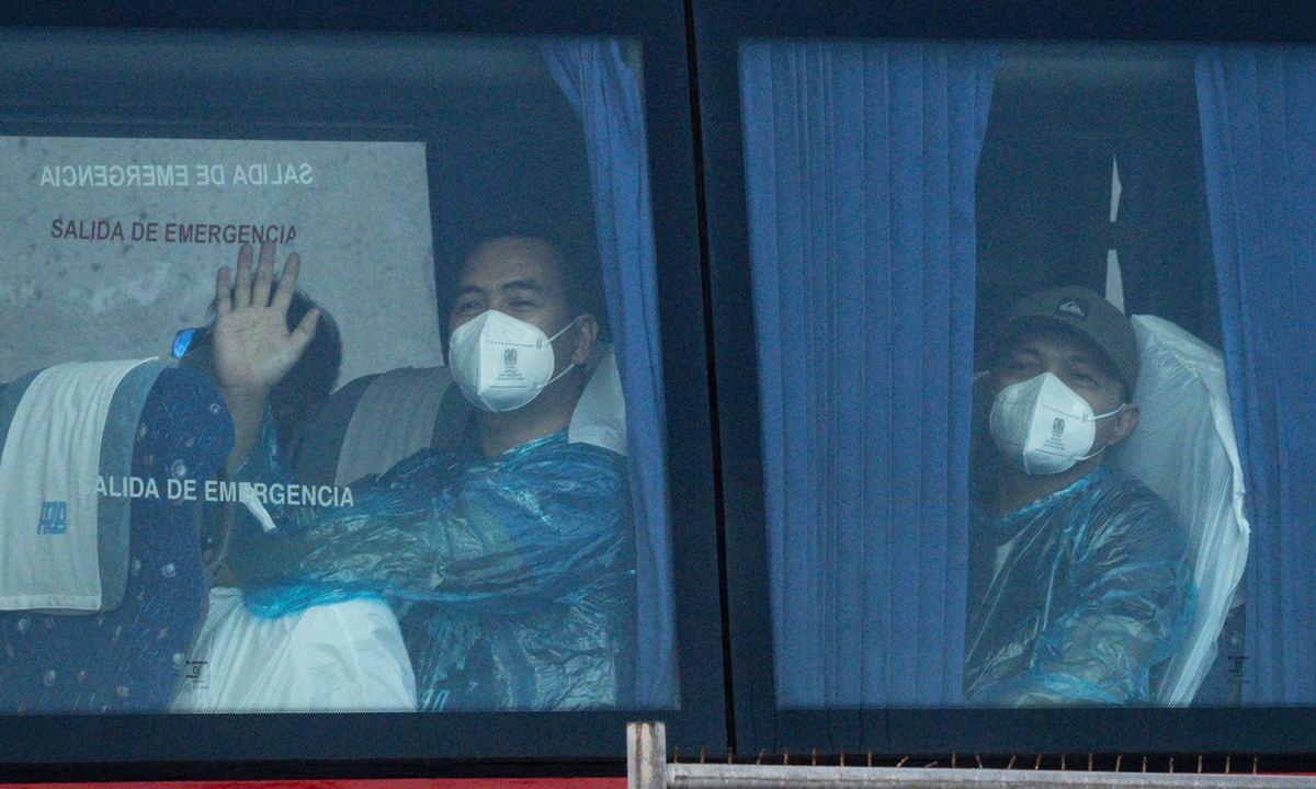 A passenger from the final group to be evacuated from the MV Hondius waves from a bus on the way to the airport in the Granadilla Port on May 11, 2026, in Tenerife, Spain. Photo: VCG
