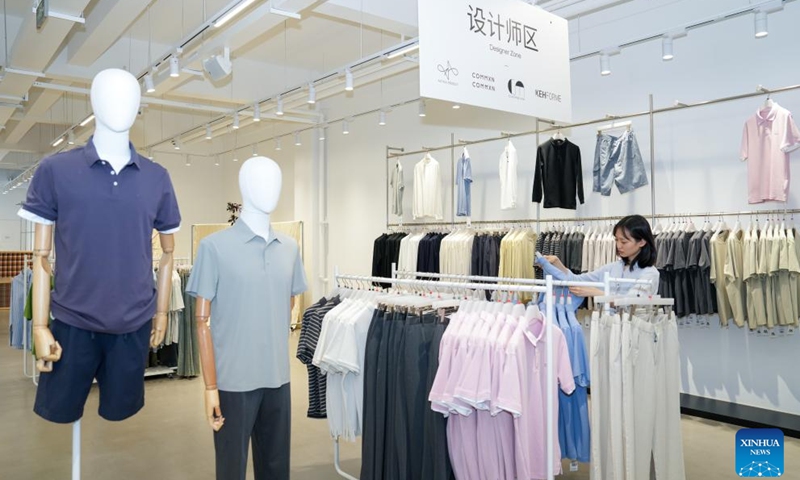 A woman selects products at a garment store at Chenfeng Fashion Creative Industrial Park in Kunshan City, east China's Jiangsu Province, May 13, 2026. Backed by leading textile and garment enterprises in the country, Kunshan has launched the Chenfeng Fashion Creative Industrial Park, which is now home to nearly 150 businesses in the fashion arena. Over 30 emerging brands have been incubated there. (Xinhua/Li Bo)

