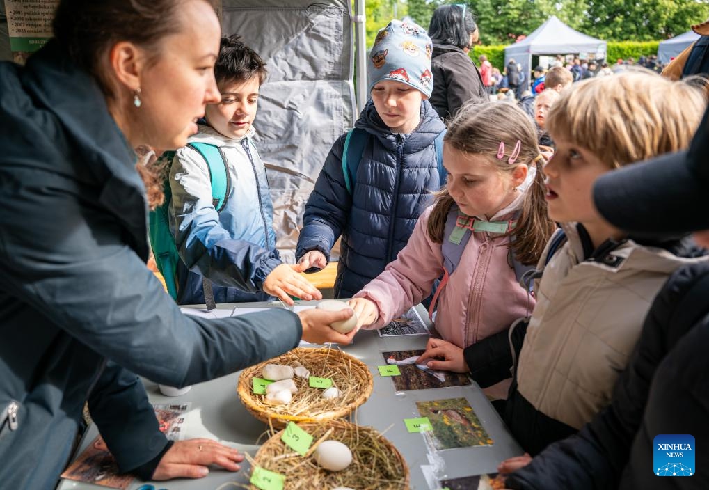 An instructor (1st L) lets children touch eggshells during an Earth Day-themed event in Prague, the Czech Republic, May 14, 2026. The event was held in Prague on Thursday, featuring educational games, workshops, and presentations. (Photo: Xinhua)