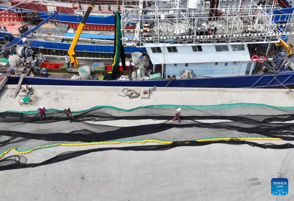 An aerial drone photo taken on May 15, 2026 shows fishers mending fishing nets during the summer fishing moratorium at a fish pier in Heiyanzi Town of Fengnan District, Tangshan, north China's Hebei Province. (Photo: Xinhua)