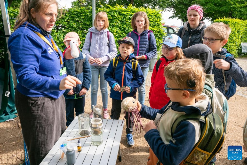 An instructor (1st L) presents models of bacteria during an Earth Day-themed event in Prague, the Czech Republic, May 14, 2026. The event was held in Prague on Thursday, featuring educational games, workshops, and presentations. (Photo: Xinhua)