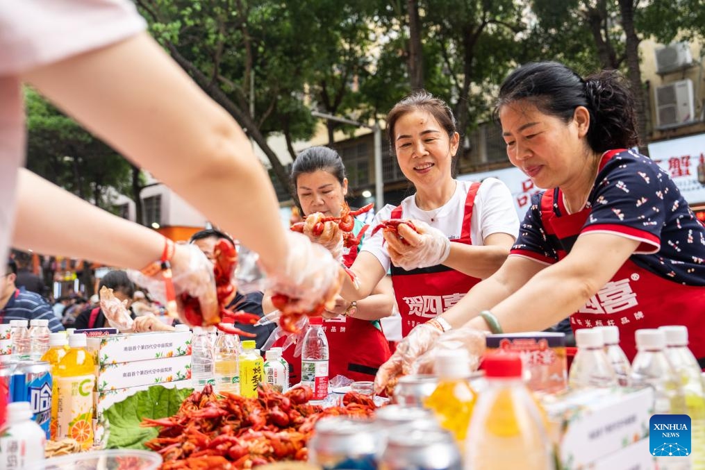 Visitors taste cooked crayfish during a grand crayfish banquet in Nanxian County, Yiyang City of central China's Hunan Province, May 15, 2026. A grand crayfish banquet was held here on Friday. Nanxian County boasts a total arable land area of 630,000 mu (about 42,000 hectares) for shared paddy rice planting and crayfish cultivation, which is now a pillar business for rural revitalization in the county. (Photo: Xinhua)