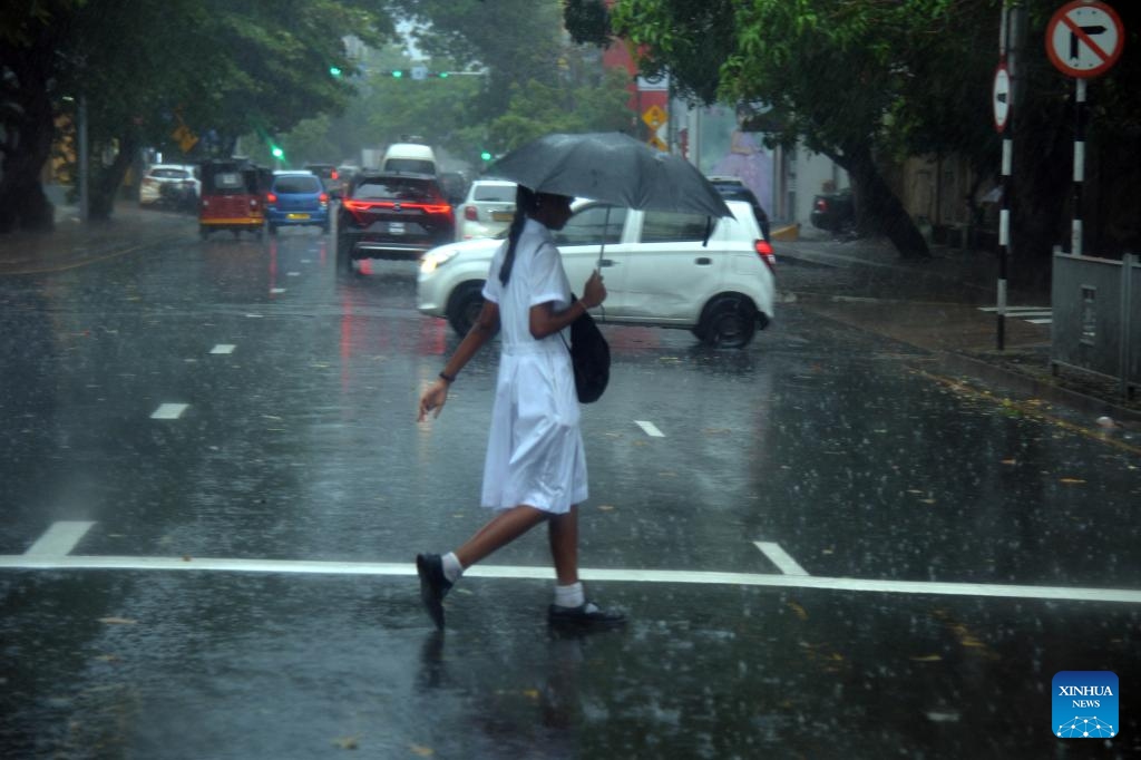 A pedestrian holding an umbrella walks across a street in the rain in Colombo, Sri Lanka, on May 14, 2026. A persistent low-pressure area has brought cloudy skies and widespread showers across several provinces in the country. (Photo: Xinhua)