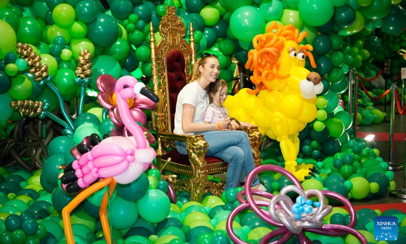 People pose for photos during the World Balloon Festival in Warsaw, Poland, May 15, 2026. The festival takes place here from May 15 to 17, featuring large themed installations featuring tropical jungles, underwater world, outer space and architectural landmarks created with more than 100,000 biodegradable balloons. (Photo by Jaap Arriens/Xinhua)