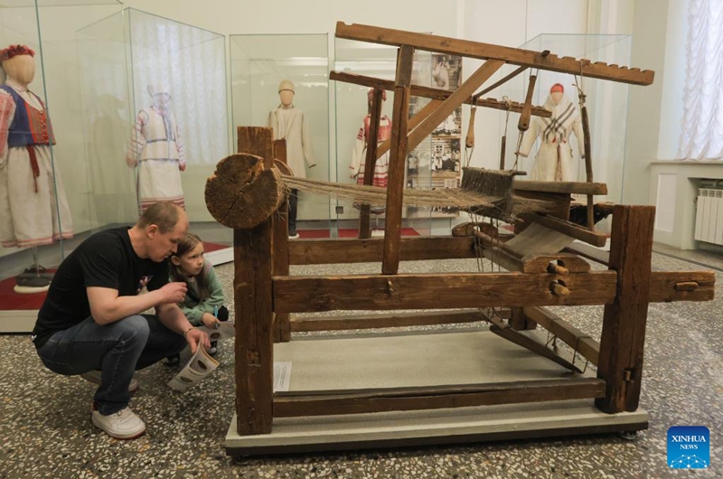 A father and his daughter look at an ancient loom at the Russian Museum of Ethnography in St. Petersburg, Russia, May 16, 2026. During the Night of Museums, an event held from May 16 to 17 in Russia, more than 140 museums, galleries, libraries, exhibition halls and concert halls stay open from evening till night, to mark the upcoming International Museum Day, observed globally on May 18. (Photo by Irina Motina/Xinhua)