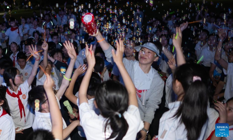 Sixth-grade students have fun during a graduation camping night event at a school in Wuchang District of Wuhan, central China's Hubei Province, May 15, 2026. The school held the event here on Friday for more than 300 sixth-grade students who are about to graduate. (Xinhua/Xiao Yijiu)