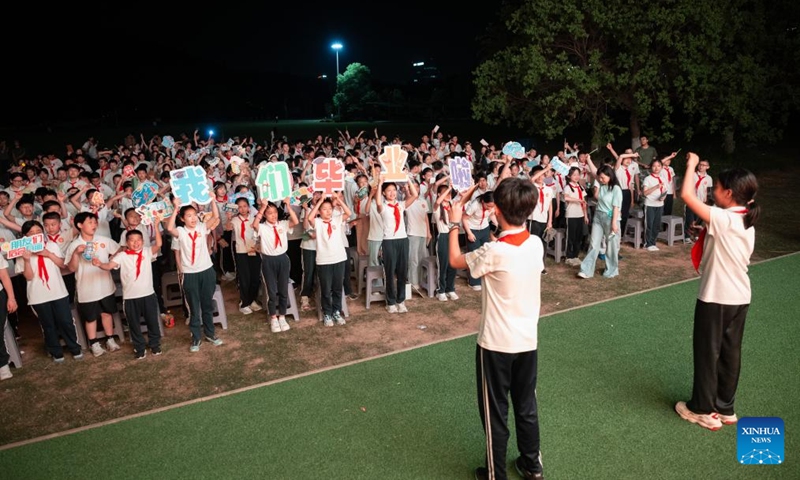 Sixth-grade students sing together during a graduation camping night event at a school in Wuchang District of Wuhan, central China's Hubei Province, May 15, 2026. The school held the event here on Friday for more than 300 sixth-grade students who are about to graduate. (Xinhua/Xiao Yijiu)