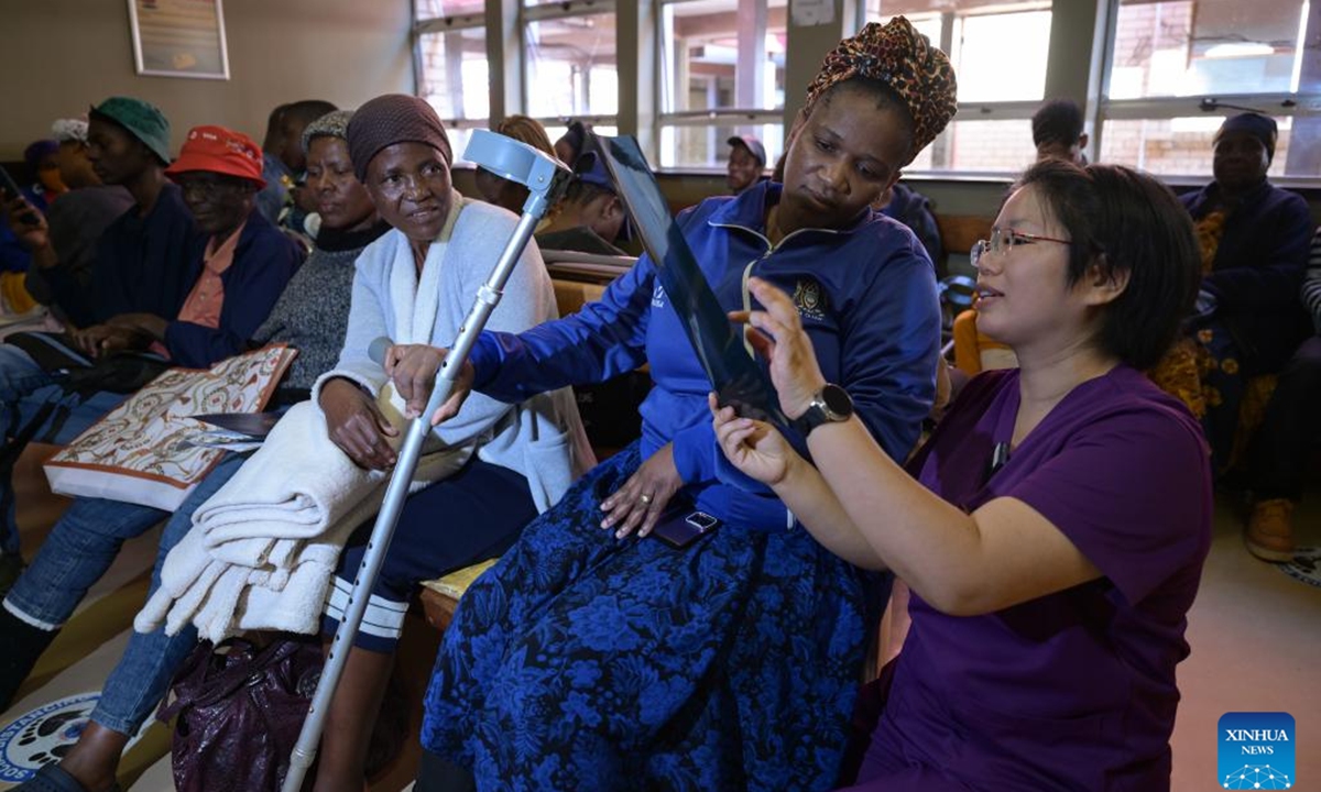 Cai Wenchao (1st R), a member of the 17th batch of the Chinese medical team to Botswana, explains the fracture recovery status to a patient at Princess Marina Hospital in Gaborone, Botswana, May 4, 2026. (Xinhua/Yang Guang)

