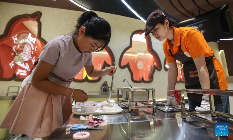 A kid (L) tries to make ice cream at an ice cream museum in Shenyang, northeast China's Liaoning Province, May 16, 2026. There are several food-themed museums in Shenyang, Liaoning Province, among which the ice cream museum is a notable example.

Located in Dadong District of Shenyang, the museum covers an area of approximately 6,000 square meters that accommodates 11 major themed zones.

In addition to displaying vintage, time-honored ice cream making machines, it also offers visitors hands-on ice cream making experiences. Blending both recreational fun and educational value, it has become a well-loved destination for tourists. Photo: Xinhua