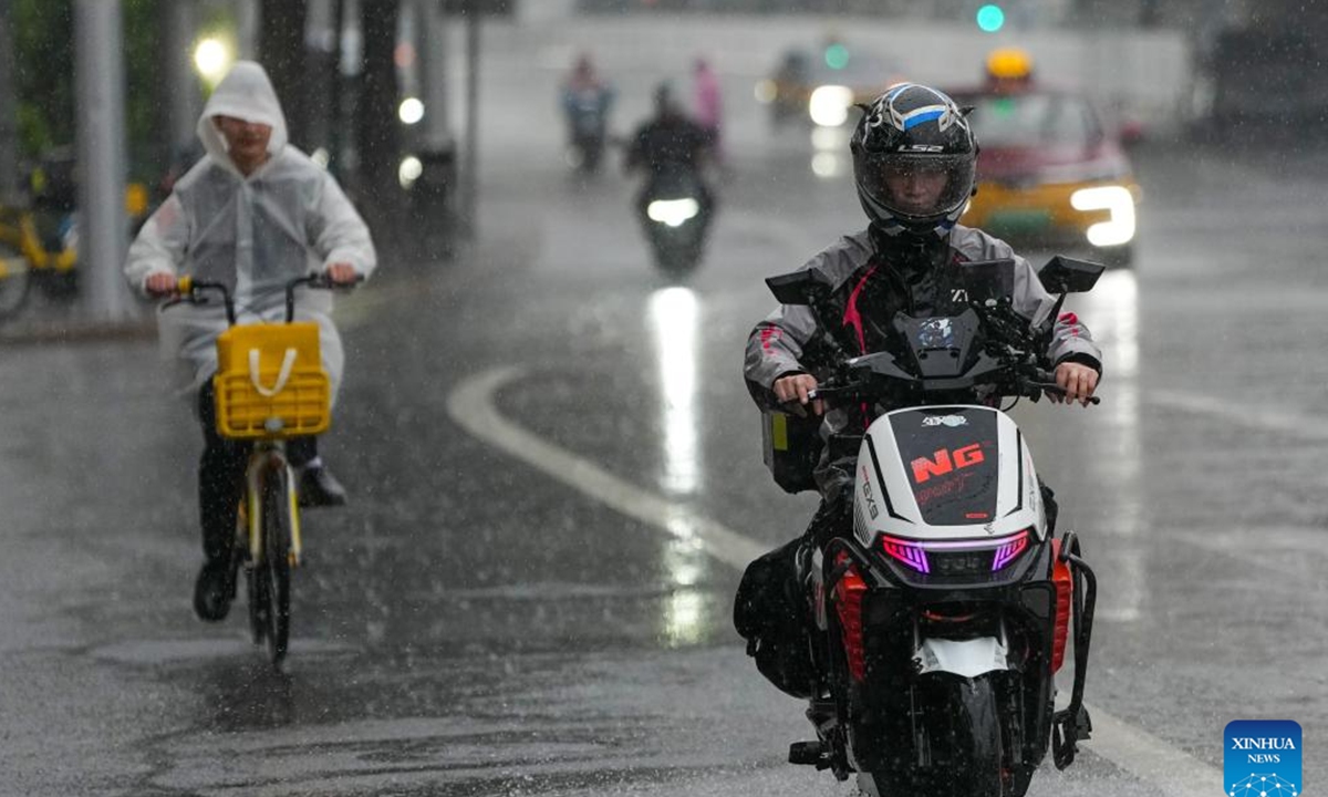 People ride in the rain in Beijing, capital of China, May 17, 2026. (Xinhua/Ju Huanzong)