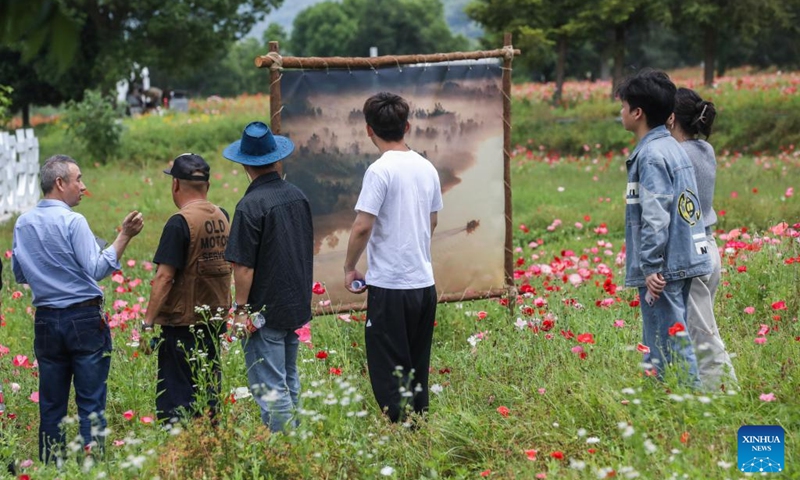 People view an open air art exhibition in Zhijiang Village of Xiaya Town, Jiande City of east China's Zhejiang Province, May 16, 2026. A photography + oil painting dual art exhibition was unveiled in Zhijiang Village of Xiaya Town on Saturday. Breaking the conventional boundaries of traditional art galleries, the exhibition is set amid fields, forests, and village paths. A total of 90 photography and oil painting works showcased the local rural customs and landscapes, with the majority of the artists being local villagers. Photo: Xinhua