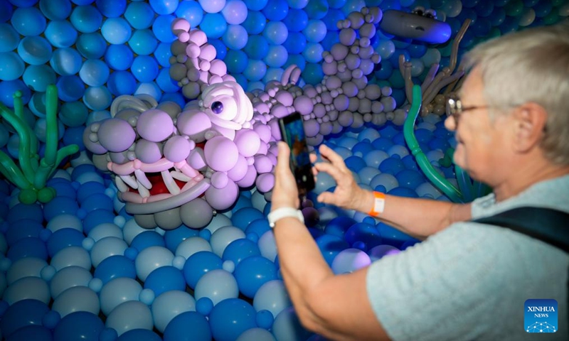 A visitor takes pictures of marine life-themed balloon installations during the World Balloon Festival in Warsaw, Poland, May 15, 2026. The festival takes place here from May 15 to 17, featuring large themed installations featuring tropical jungles, underwater world, outer space and architectural landmarks created with more than 100,000 biodegradable balloons. (Photo by Jaap Arriens/Xinhua)