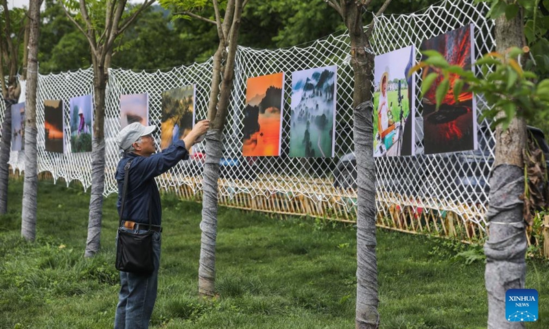 A man views an open air art exhibition in Zhijiang Village of Xiaya Town, Jiande City of east China's Zhejiang Province, May 16, 2026. A photography + oil painting dual art exhibition was unveiled in Zhijiang Village of Xiaya Town on Saturday. Breaking the conventional boundaries of traditional art galleries, the exhibition is set amid fields, forests, and village paths. A total of 90 photography and oil painting works showcased the local rural customs and landscapes, with the majority of the artists being local villagers. Photo: Xinhua