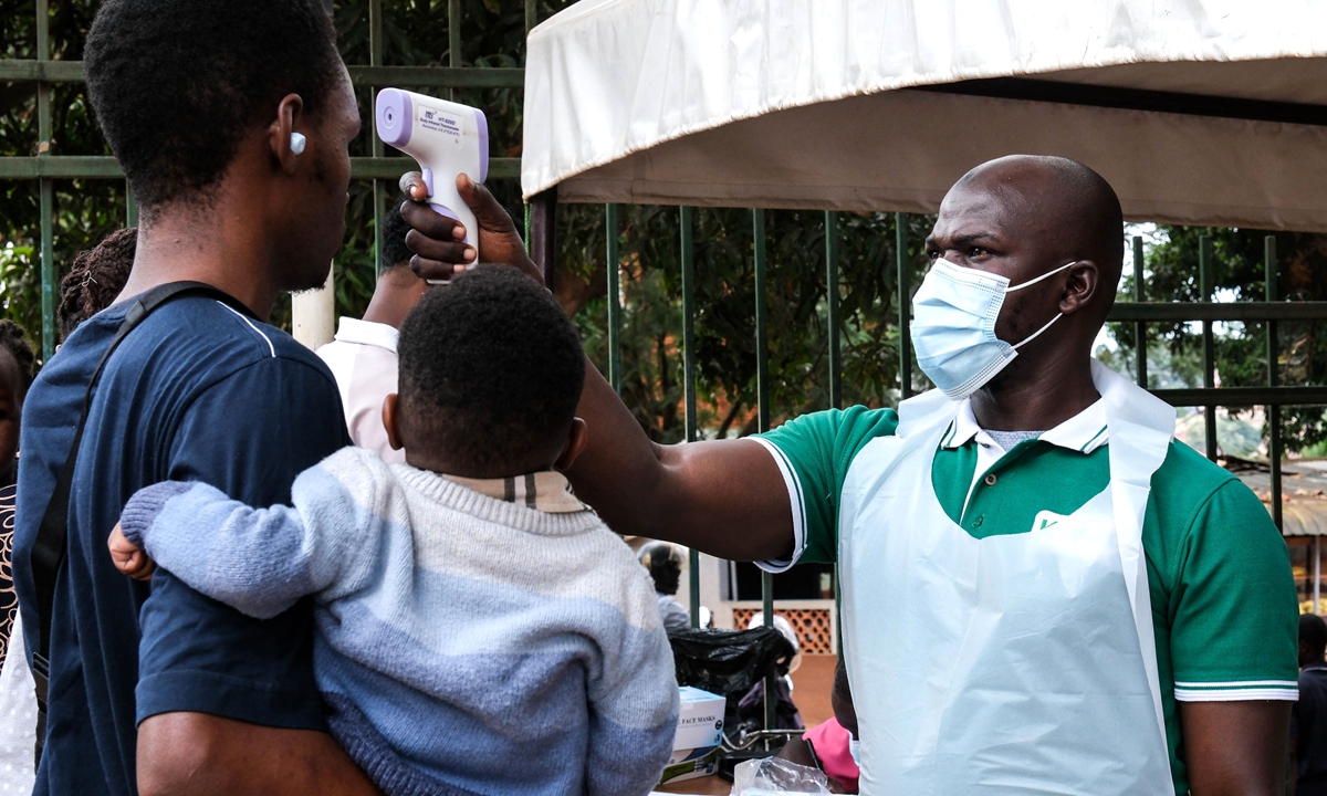 A health official uses a thermometer to measure people's temperatures in front of Kibuli Muslim Hospital in Kampala, Uganda, on Saturday, May 16, 2026. Photo: VCG