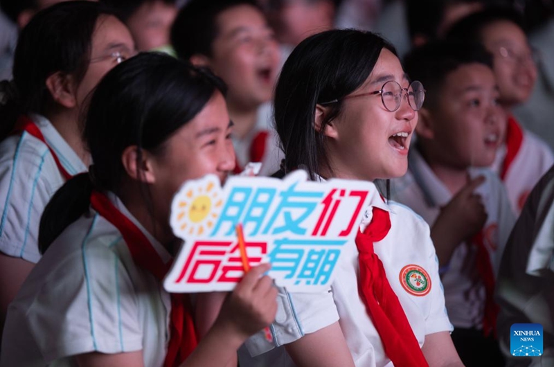 Sixth-grade students watch a video featuring memories of their school life during a graduation camping night event at a school in Wuchang District of Wuhan, central China's Hubei Province, May 15, 2026. The school held the event here on Friday for more than 300 sixth-grade students who are about to graduate. (Xinhua/Xiao Yijiu)
