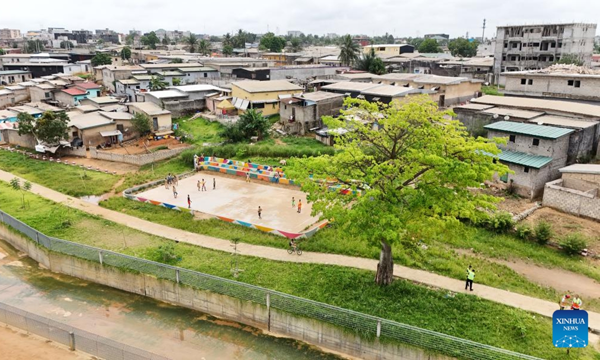 An aerial drone photo taken on April 22, 2026 shows a newly-built drainage channel and a football field along it in the Abobo commune in northern Abidjan, Cote d'Ivoire. (Power Construction Corporation of China/Handout via Xinhua)


