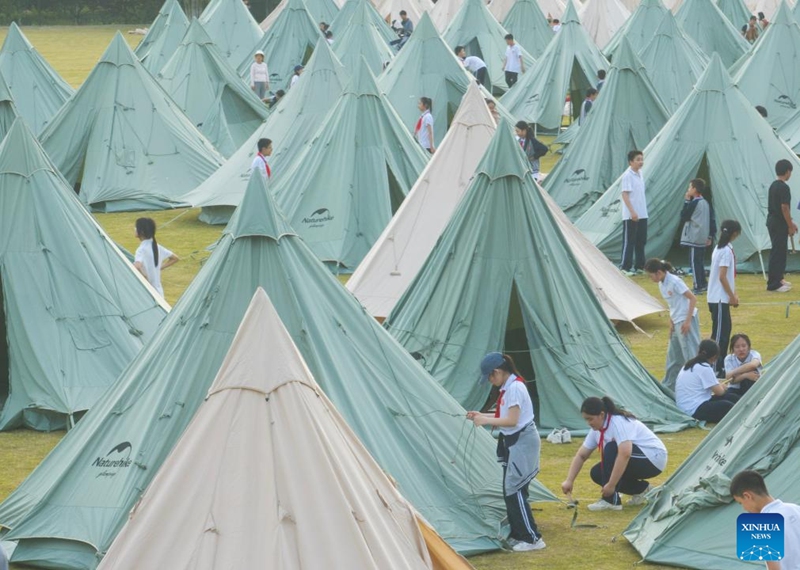 An aerial drone photo taken on May 15, 2026 shows sixth-grade students putting up tents during a graduation camping night event at a school in Wuchang District of Wuhan, central China's Hubei Province. The school held the event here on Friday for more than 300 sixth-grade students who are about to graduate. (Xinhua/Xiao Yijiu)