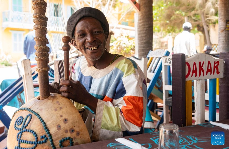 A musician plays kora, a string instrument from West Africa, on Goree Island in Senegal, May 16, 2026. Goree Island lies off the coast of Senegal, opposite Dakar. Ruled in succession by the Portuguese, Dutch, English and French, it was the largest slave-trading center on the African coast from the 15th to the 19th century. (Xinhua/Xie Jianfei)